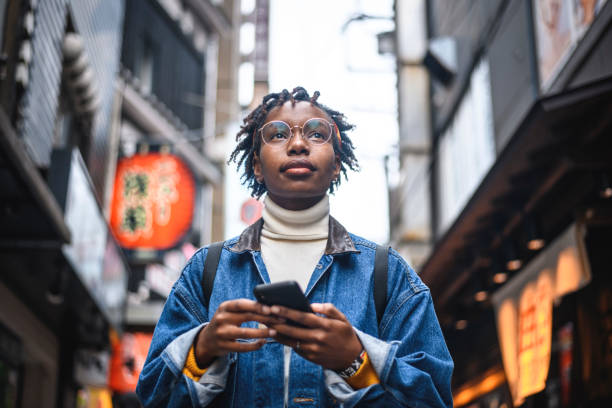 african woman with smartphone vacationing in tokyo - people tourism tourist travel destinations imagens e fotografias de stock