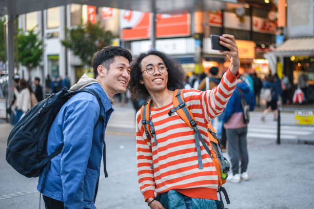 istock Young Japanese Backpackers Pausing for a Selfie in Tokyo 1155295754