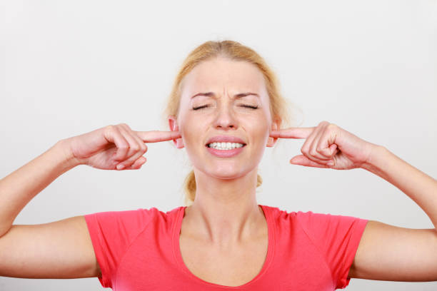 istock Woman closing ears with fingers, big noise. 1155299020