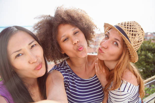 istock Mixed race female friends making a duck face selfie 1155303708