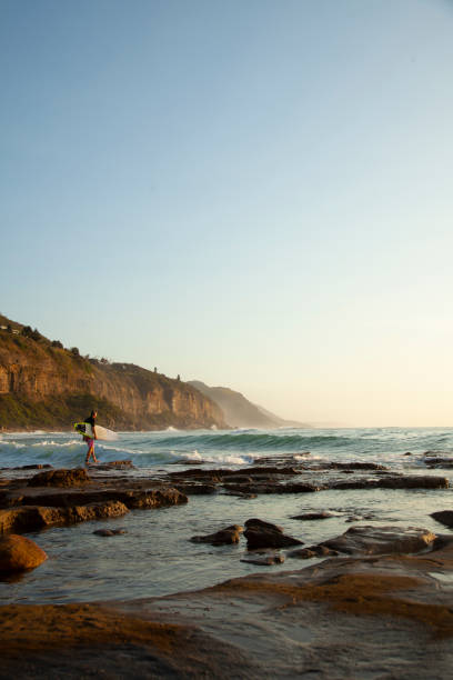 istock A lone surfer at rocky beach 1155314623