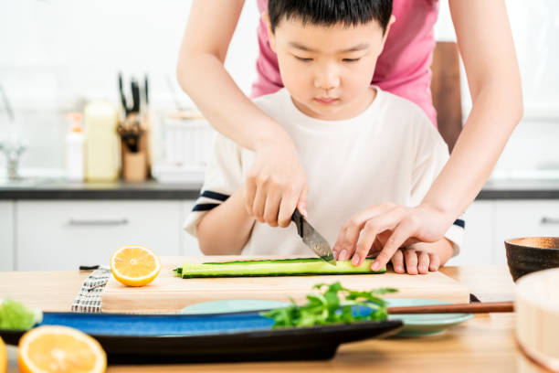 istock Asian boy learning to prepare food of making sushi roll 1155317059