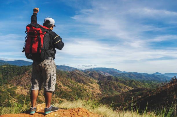 istock Traveler Man with backpack hands raised mountains landscape on background. 1155317678