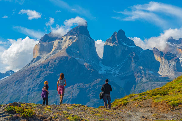 Torres del Paine Adventure, Patagonia Three tourists during a hiking adventure inside Torres del Paine national park, looking upon the Andes peaks of Cuernos del Paine, Patagonia, Chile. cuernos del paine stock pictures, royalty-free photos & images