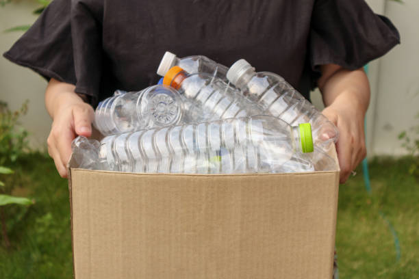 istock Hand holding brown recycle garbage box with plastic bottles 1155320420