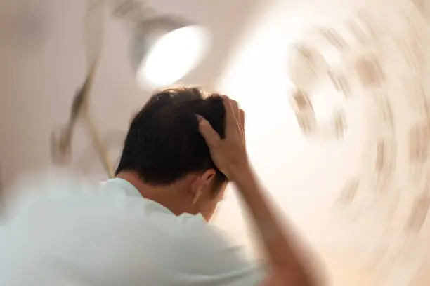 Photo of Vertigo illness concept. Man hands on his head felling headache dizzy sense of spinning dizziness,a problem with the inner ear, brain, or sensory nerve pathway.