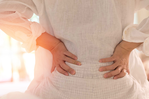 Dolor de espalda en concepto de mujer. Paciente hembra herida por dolor de espalda menor por problemas intestinales y vesicales, enfermedad inflamatoria palvical (EIP) o embarazo por maternidad. photo