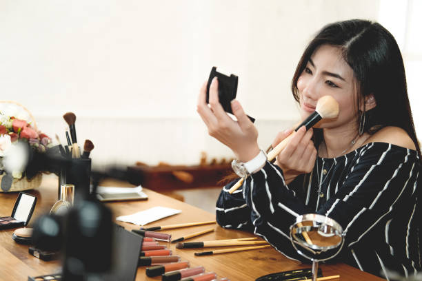 istock asian woman applying makeup cosmetic 1155320591