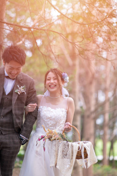 Happy bride and groom walking in forest