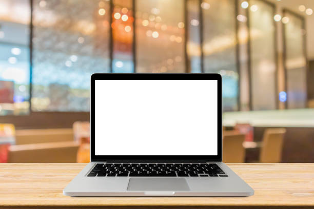 istock Blank screen laptop computer on wood table top with blur cafe restaurant with abstract bokeh light defocused background 1155321432