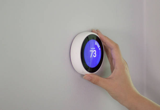 Using smart thermostat to change tempreture Smart home smart thermostat stock pictures, royalty-free photos & images