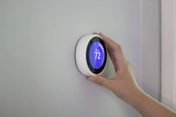 Using smart thermostat to change tempreture Smart home smart thermostat photos stock pictures, royalty-free photos & images