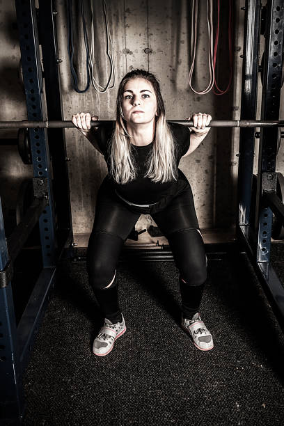 istock Young woman weight training in a gritty basement gym. 1155326232