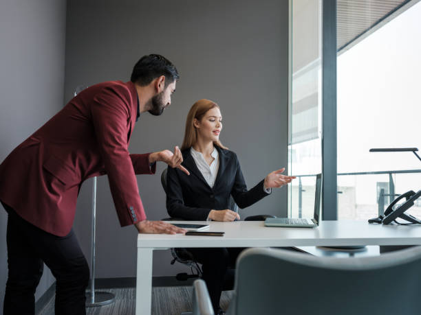 istock Male and female professionals discussing information from a laptop 1155328021