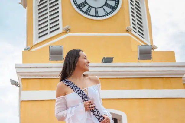 Beautiful woman walking around Cartagena de Indias next to the famous Clock Tower