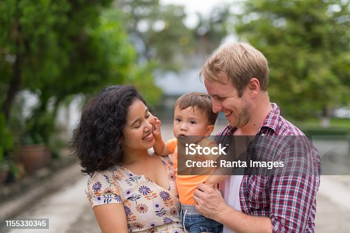 istock Portrait of happy multi-ethnic family bonding together outdoors 1155330345