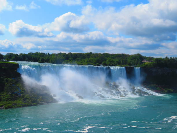istock Niagara Falls flowing with water spray and cloudscape above 1155333368