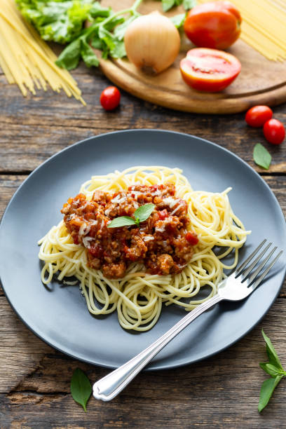 istock Spaghetti on black plate on wooden background. top view 1155340449