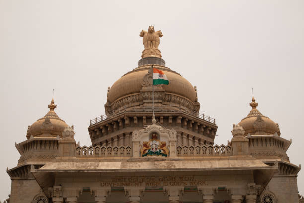 индийский флаг развевается на куполе видханы судхи в бангалуру, индия - bangalore india parliament building building exterior стоковые фото и изображения