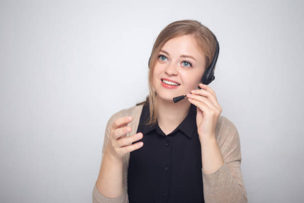young caucasian woman is talking on the headset phone in a call center - asking on the phone call center customer service representative imagens e fotografias de stock