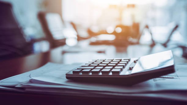 fermez la calculatrice sur le bureau de travail d’affaires, fond sombre. - banqueroute photos et images de collection