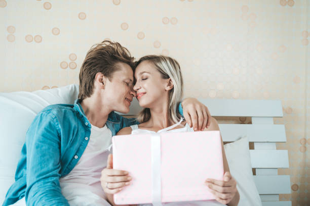 istock Boyfriend surprise his girlfriend with gift box on the bed 1155348767