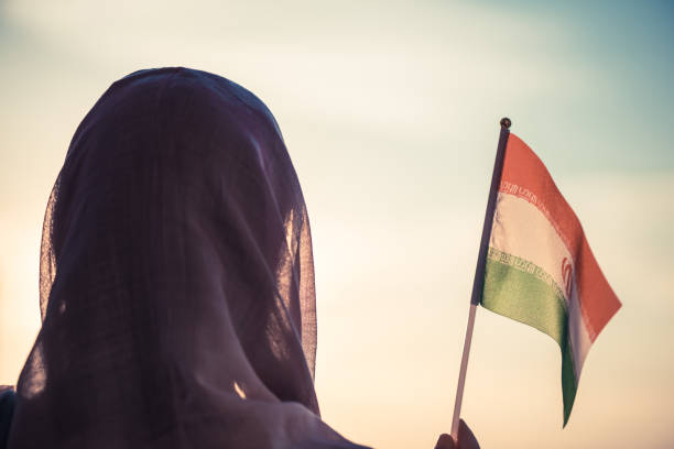 donna musulmana in sciarpa con bandiera iraniana al tramonto. concetto - teheran foto e immagini stock