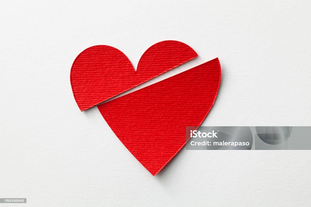 Broken heart. Red cut paper heart on a white background. Broken Heart Stock Photo