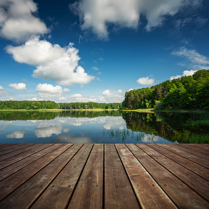 Wooden floor and beautiful lake on the background
