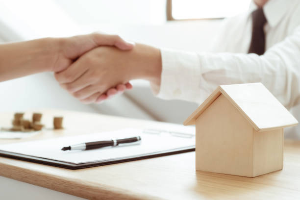 istock insurance agent hand shaking with customer with property contract. 1155357084