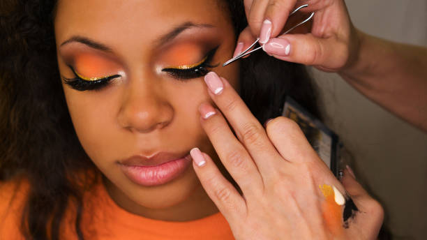 Makeup artist applies makeup on face of girl stock photo