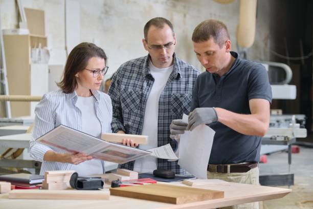 istock Team of woodworking workshop workers are discussing. Group of people client, designer or engineer and workers discuss work 1155360746