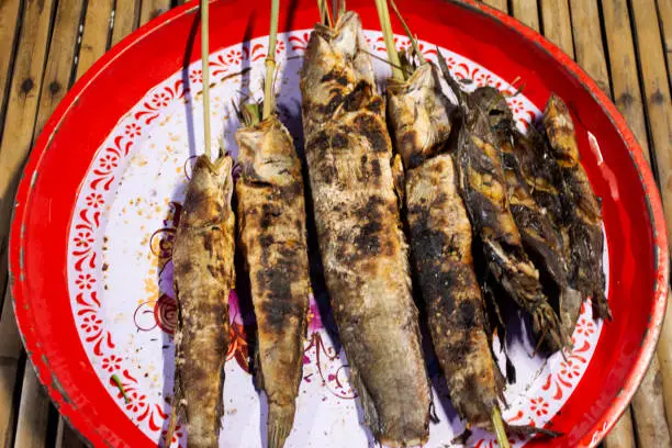 Photo of Salt crusted grilled freshwater fishes thai style on retro vintage steel tray