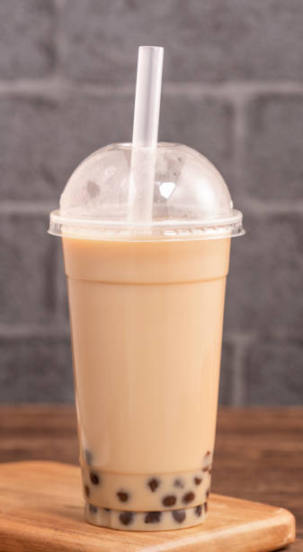 istock Takeout with disposable item concept popular Taiwan drink bubble milk tea with plastic cup and straw on wooden table background, close up, copy space 1155367458