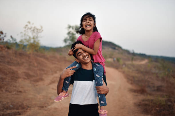 istock Brother takes his young sister piggyback while hiking 1155368404