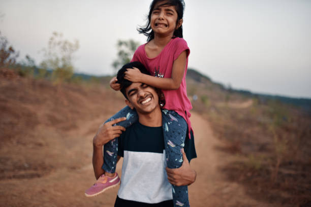 istock Brother takes his young sister piggyback while hiking 1155368585