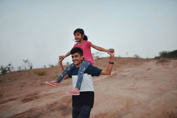 istock Brother takes his young sister piggyback while hiking 1155368894