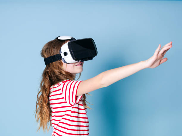 istock smiling positive girl wearing virtual reality glasses goggles headset, vr box 1155369630