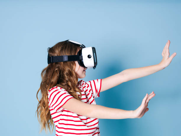 istock smiling positive girl wearing virtual reality glasses goggles headset, vr box 1155369633