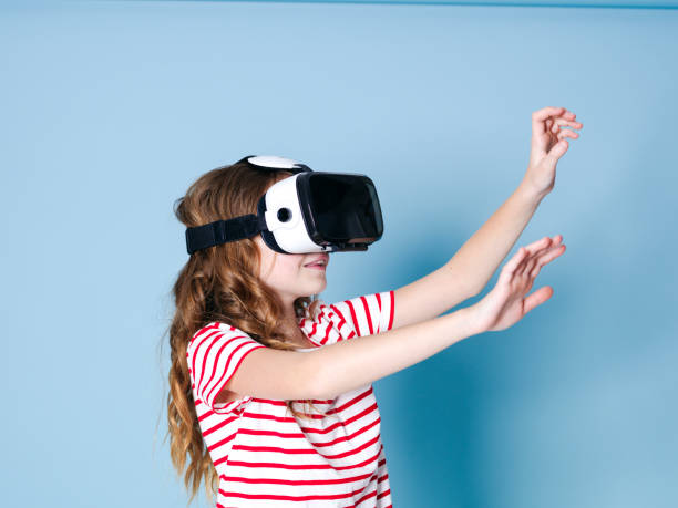istock smiling positive girl wearing virtual reality glasses goggles headset, vr box 1155369640
