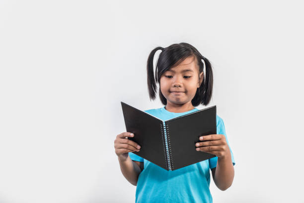 istock little girl reading book in studio shot 1155372157
