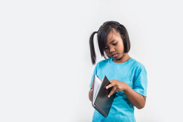 istock little girl reading book in studio shot 1155372223