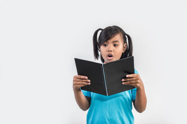 istock little girl reading book in studio shot 1155372227