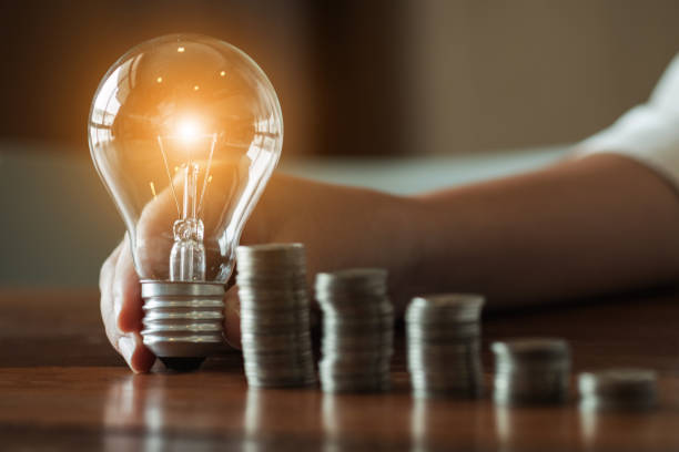 istock woman hands holding light bulb in working place. 1155372290