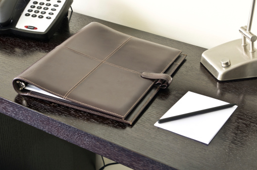 Brown leather paper folder on desk