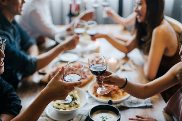 Group of joyful young Asian man and woman having fun and toasting with red wine during party Group of joyful young Asian man and woman having fun and toasting with red wine during party blind date stock pictures, royalty-free photos & images