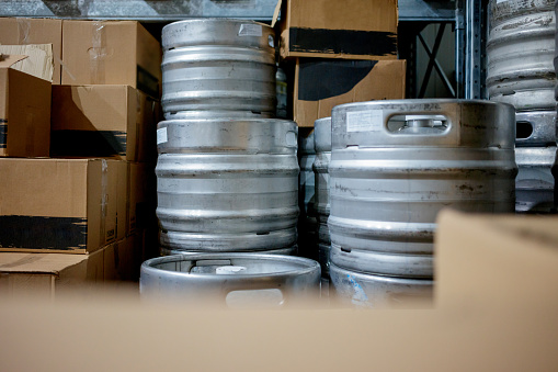 Range of stacked beer casks of kegs in warehouse