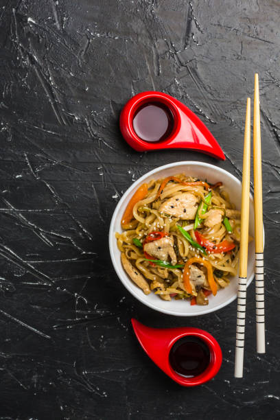 noodles cinesi in una scatola con pollo e verdure con bastoncini - hokkien foto e immagini stock