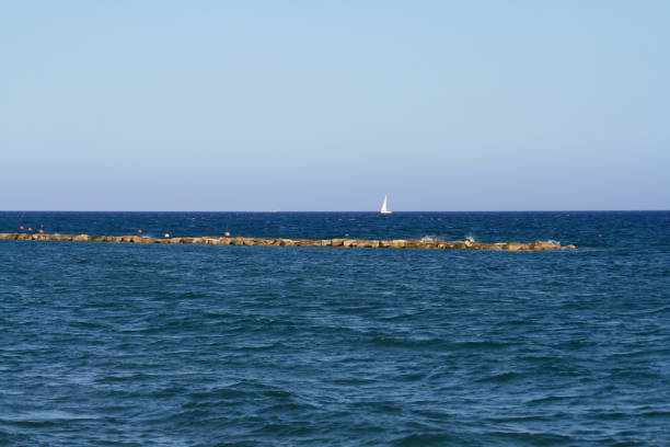 istock Blue sea with white sail on horizon 1155384758
