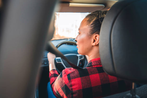 istock Young woman driving car on a sunny day 1155385473